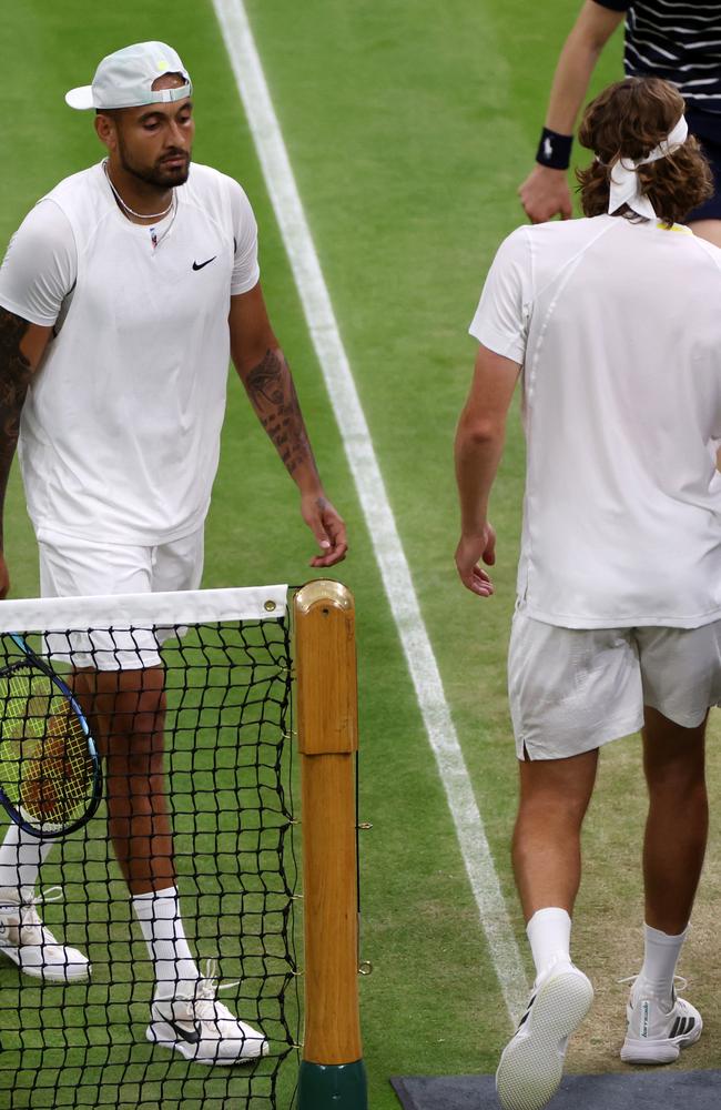 Nick Kyrgios of Australia walks past Stefanos Tsitsipas