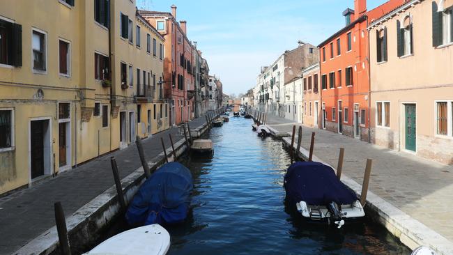 A canal and the roads next to it are seen completely empty in Venice.