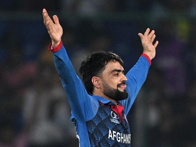 Afghanistan's Rashid Khan celebrates after taking the wicket of England's Mark Wood during the 2023 ICC Men's Cricket World Cup one-day international (ODI) match between England and Afghanistan at the Arun Jaitley Stadium in New Delhi on October 15, 2023. (Photo by Money SHARMA / AFP) / -- IMAGE RESTRICTED TO EDITORIAL USE - STRICTLY NO COMMERCIAL USE --