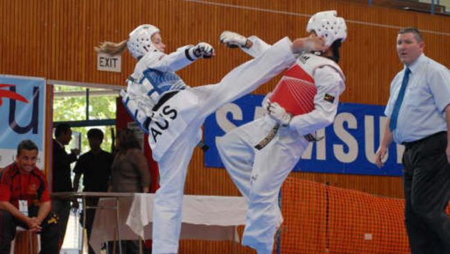 Cassie (in blue) executes a roundhouse kick to her opponent’s head.