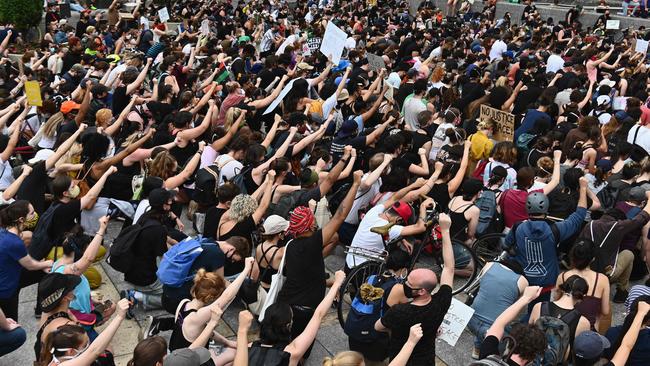 Protesters take a knee and raise their fists during a "Black Lives Matter" demonstration in front of the Brooklyn Library in New York.