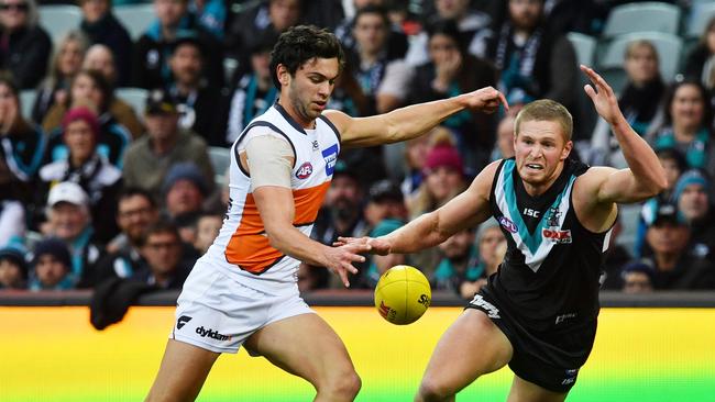 Tom Clurey attempts to smother Giant Tim Taranto. Picture: AAP Image/David Mariuz