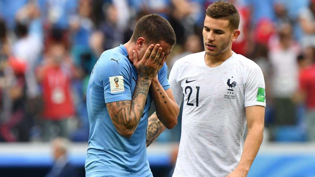 France's defender Lucas Hernandez (R) consoles Uruguay's defender Jose Gimenez
