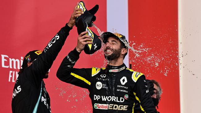 Lewis Hamilton spills champagne from his shoe over third placed Renault's Australian driver Daniel Ricciardo. Picture: AFP