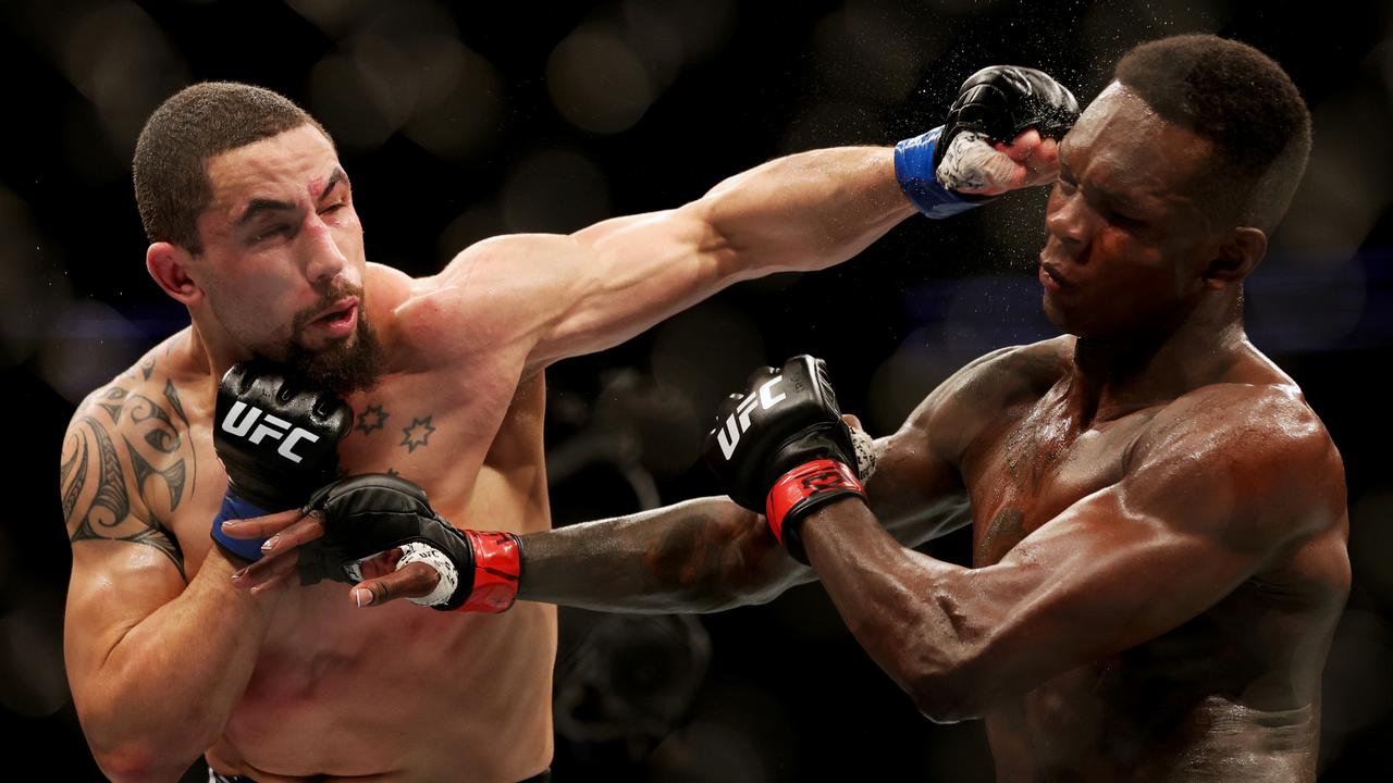 HOUSTON, TEXAS - FEBRUARY 12: Robert Whittaker of Australia punches Israel Adesanya of Nigeria in their middleweight championship fight during UFC 271 at Toyota Center on February 12, 2022 in Houston, Texas. (Photo by Carmen Mandato/Getty Images)