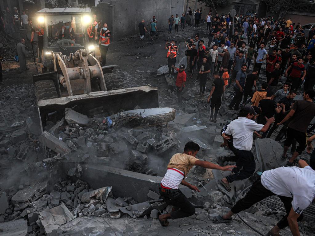 A bulldozer clears rubble as people gather in a neighbourhood in Rafah in the southern Gaza Strip after it was hit by an Israeli strike. Picture: AFP