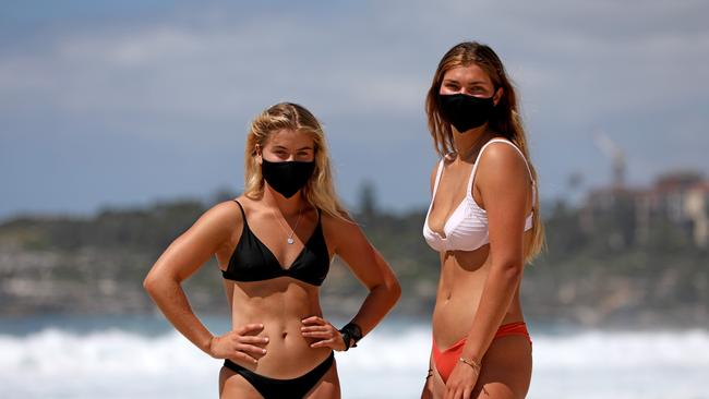 Compared to other nations Australia has been relatively untouched by the global pandemic. Isabella Kulling and Abigail Dodgson in the sun Bondi beach with masks on. Picture: Damian Shaw