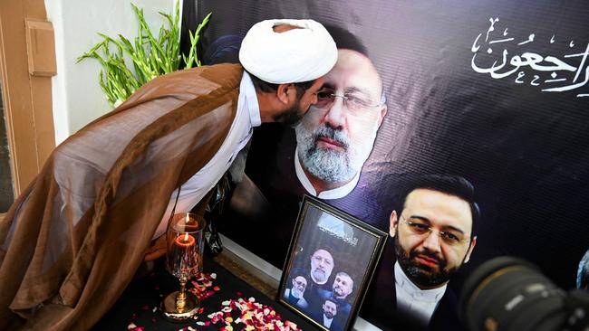 A man kisses the portrait of Iranian president Ebrahim Raisi who died in a helicopter crash, during a condolence ceremony. Picture: AFP