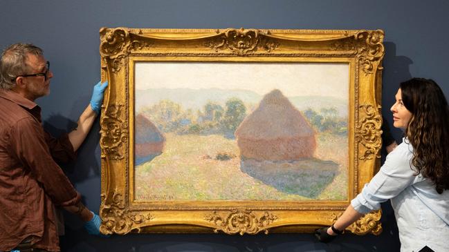 Art technician Chas Glover and Tweed Regional Gallery Curator - Exhibitions Tina Wilson hanging Claude Monet's masterpiece Meules, milieu du jour [Haystacks, midday], 1890, on November 1, 2023 as part of the National Gallery of Australia's Sharing the National Collection Initiative. Picture: Luke Marsden/ Tweed Regional Gallery.