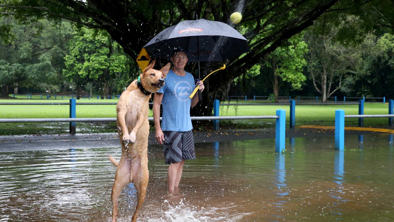 Muttley the dog enjoys running through the puddles at Goomboora Park with owner Simon Boyd. PICTURE: ANNA ROGERS