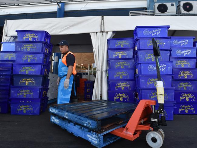 A worker stacks containers of seafood during the Christmas trade period. Picture: Mick Tsikas