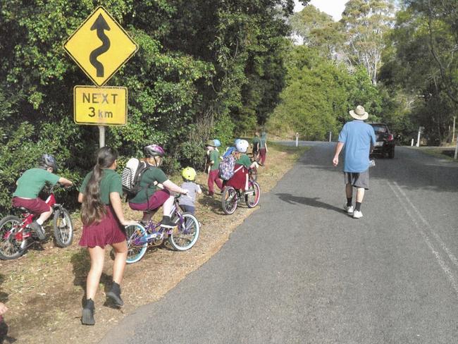Parents check on children leaving school along a busy stretch of  hinterland road at Springbrook which lacks a footpath.