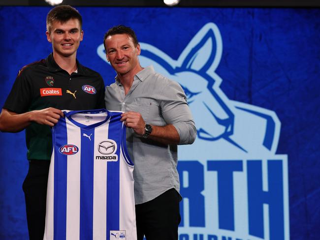 Launceston’s Colby McKercher receives his jumper from North Melbourne legend Brent Harvey after he was taken at pick two by the Kangaroos in Monday night’s AFL Draft. Pic: Michael Klein