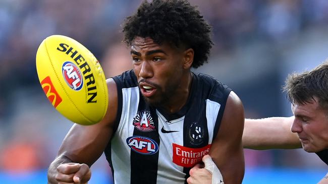 MELBOURNE, AUSTRALIA - APRIL 25: Isaac Quaynor of the Magpies handballs whilst being tackled by Jye Menzie of the Bombers during the round six AFL match between Collingwood Magpies and Essendon Bombers at Melbourne Cricket Ground, on April 25, 2023, in Melbourne, Australia. (Photo by Quinn Rooney/Getty Images)