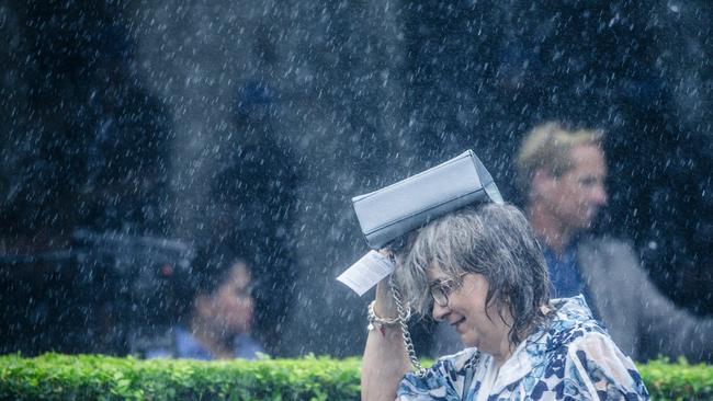 Heavy showers hit punters enjoying the Magic Millions after race three on the Gold Coast. Picture: Glenn Campbell