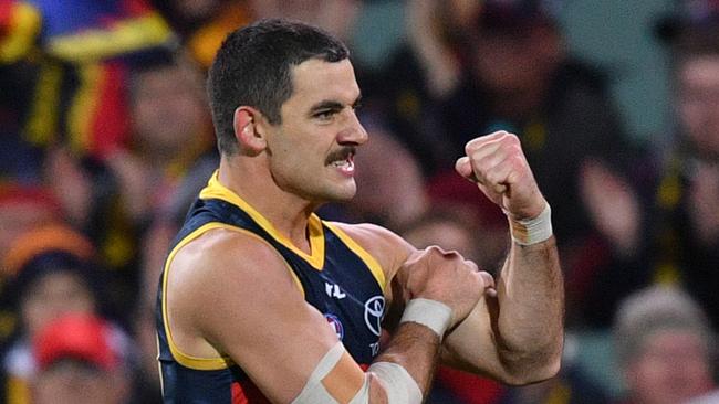 Crows player Taylor Walker grabs the black tape on his arm, in honour of much loved Crows staff member Jason Lehmann who died the morning of the match. Picture: AAP / David Mariuz