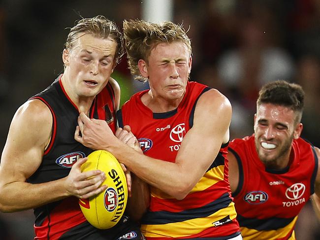 MELBOURNE, AUSTRALIA - APRIL 10: Mason Redman of the Bombers and Brayden Cook of the Crows contest the ball during the round four AFL match between the Essendon Bombers and the Adelaide Crows at Marvel Stadium on April 10, 2022 in Melbourne, Australia. (Photo by Daniel Pockett/Getty Images)