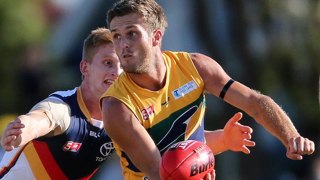 Strong ... Woodville-West Torrens’ Jarred Allmond handpasses ahead of Crow Dean Gore. Picture: Calum Robertson