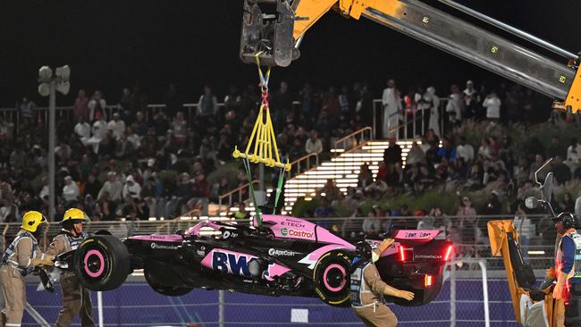 A crane lifts Esteban Ocon’s car off the track in Qatar. (Photo by Andrej ISAKOVIC / AFP)