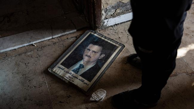 A picture of toppled Syrian president Bashar al-Assad lies abandoned in a Damascus street. Picture: AFP