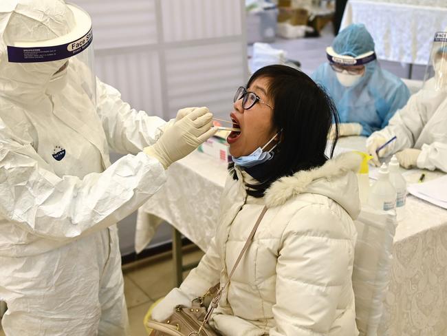 Health officials in Hanoi test a woman for coronavirus. Picture: AFP