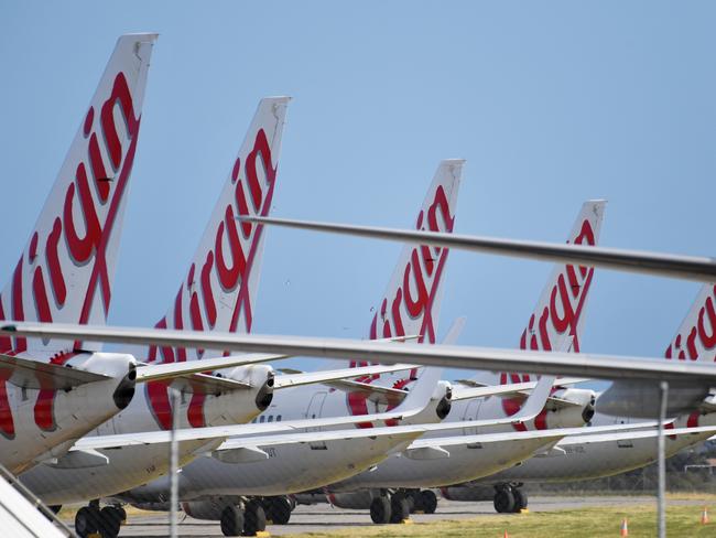 Virgin Australia planes parked on the tarmac at Adelaide Airport in Adelaide, Tuesday, April 21, 2020. The airline has gone into voluntary administration. (AAP Image/David Mariuz) NO ARCHIVING