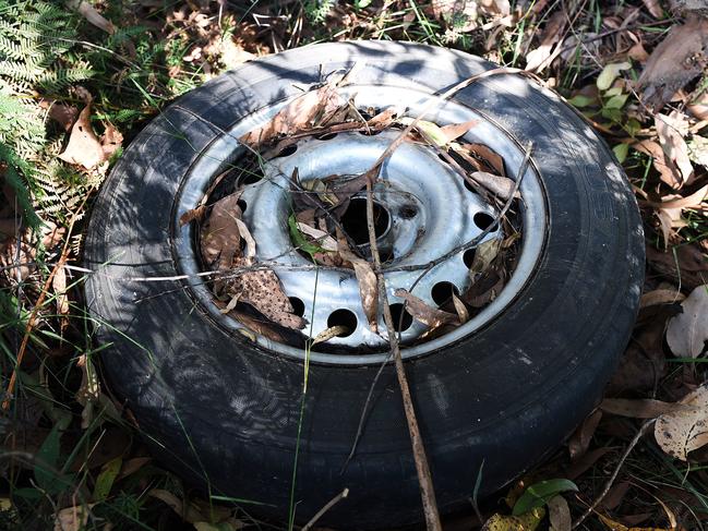 An abandoned tyre is among the rubbish littered along the Yarra River bank.