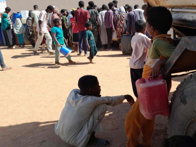 People queue for water in Omdurman, the Sudanese capital's twin city, during battles between the Sudanese military forces and paramilitary Rapid Support Forces (RSF), on January 17, 2025. Since April 2023, Sudan has been at war between the forces of rival generals vying for control. Most of Omdurman is under the Sudanese army control, while the rival paramilitary Rapid Support Forces (RSF) hold Khartoum North and some other areas of the capital. (Photo by AFP)