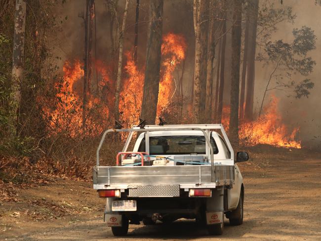 Local residents are seen near a bushfire burning in Busbys Flat, northern NSW, Wednesday, October 9, 2019. (AAP Image/Jason O'Brien)