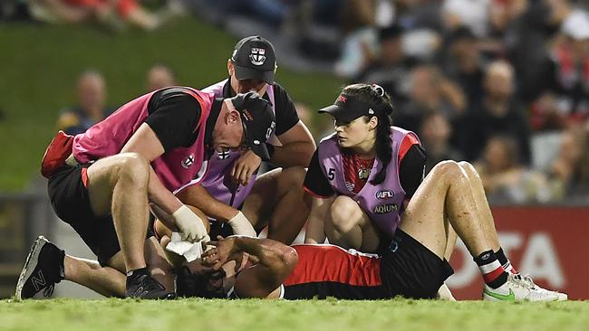 CAIRNS, AUSTRALIA – JUNE 12: Hunter Clark of the Saints receives attention during the round 13 AFL match between the St Kilda Saints and the Adelaide Crows at Cazaly's Stadium on June 12, 2021 in Cairns, Australia. (Photo by Albert Perez/AFL Photos/via Getty Images)