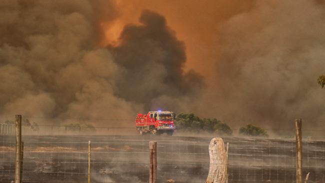 A fire truck against a backdrop of billowing smoke. Picture: Alex Coppel