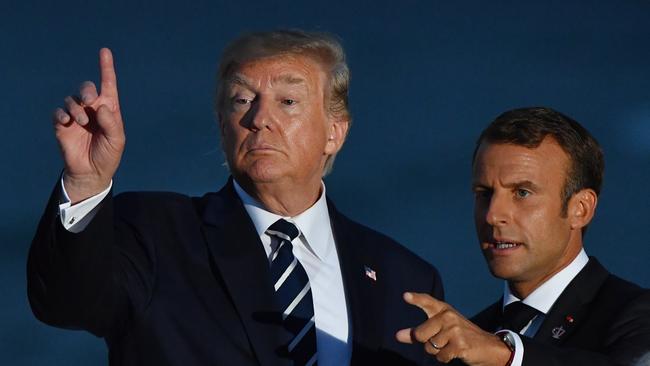 U.S. President Donald Trump and France's President Emmanuel Macron gesture after the family photograph during the G7 Summit in the town of Biarritz, 800km south of Paris in France, Sunday, August 25, 2019.  (AAP Image/Mick Tsikas) NO ARCHIVING