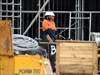 Construction workers walk through a work site