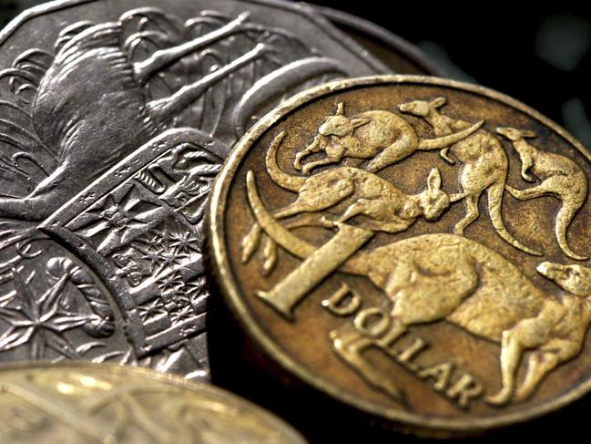 Australian $1 sits over a 50c coins in generic image of Australian currency money.