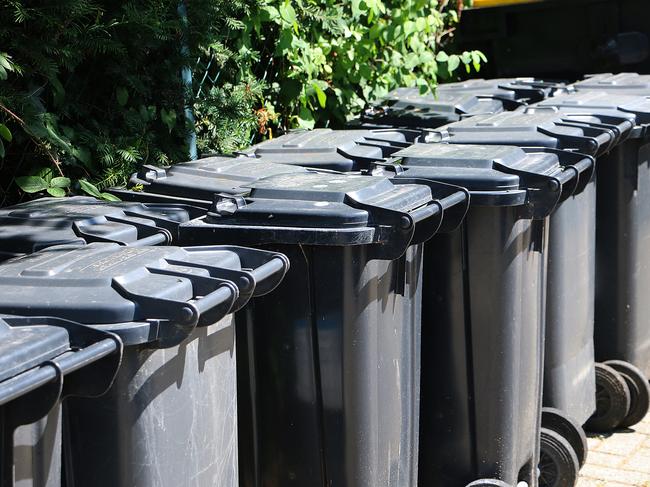 Wheelie bins on a pavement waiting for rubbish collection, UK.