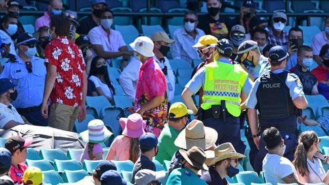 Spectators being escorted out after allegedly some remarks were made on the fourth day of the third Test match between Australia and India at the SCG. Picture: Saeed Khan/AFP