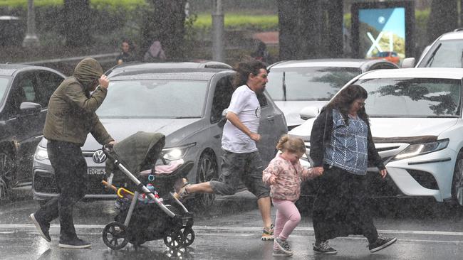 Commuters get caught in a sudden downpour in Sydney’s city centre on Friday. Picture: NCA NewsWire / Simon Bullard.