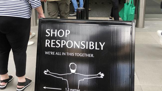 Signs at one of Chadstone shopping centre’s entrances, encouraging social distancing. Picture: David Crosling