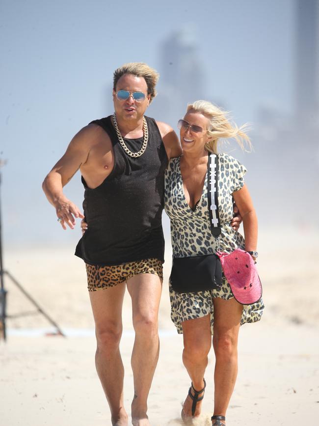 Warwick Capper and partner Lisa Arocca enjoy a stroll along Main Beach, Gold Coast, during a break in filming for an Ultra Tune TV ad. pic: Nathan Richter
