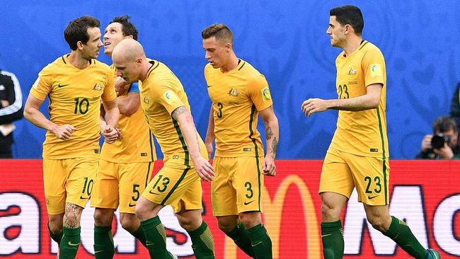 Australia's midfielder Mark Milligan (2nd L) is congratulated by forward Robbie Kruse (L).