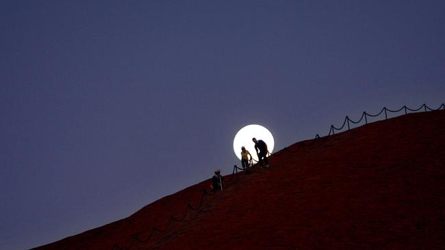 People climbing Uluru late in the evening. Picture: LINDSAY MOLLER