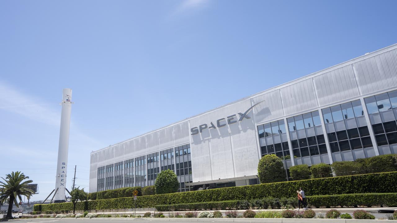 Exterior view of the SpaceX headquarters with recovered Falcon 9 rocket booster on display in Hawthorne, California.