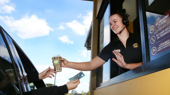 Zarraffas Pimpama staff member Bridget O'Brie informs local Connor Hutton his coffee has already been paid for in the Pay it Forward movement sweeping the area. Picture Glenn Hampson