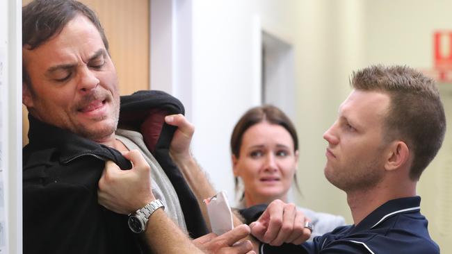 A scene from a short film being shot at Griffith University with boxer Jeff Horn (right) and featuring Brad McMurray (left) and Ally Wright (background). Picture Glenn Hampson