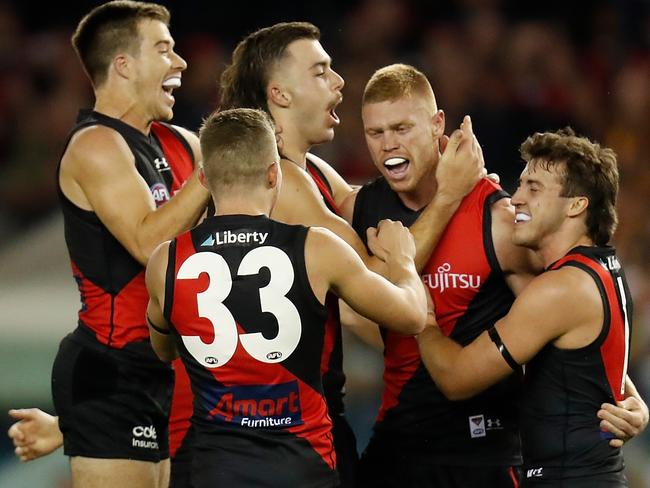 MELBOURNE, AUSTRALIA - MARCH 20: Peter Wright of the Bombers celebrates a goal with teammates during the 2021 AFL Round 01 match between the Essendon Bombers and the Hawthorn Hawks at Marvel Stadium on March 20, 2021 in Melbourne, Australia. (Photo by Michael Willson/AFL Photos via Getty Images)