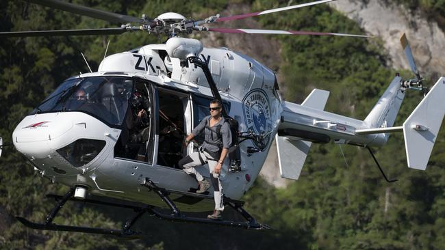 Bear Grylls clings to a helicopter during the race. Picture: Corey Rich/Amazon