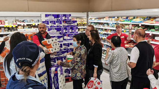 Police watch on as shoppers descend on toilet paper at Coles in Epping in Sydney. Picture: AAP