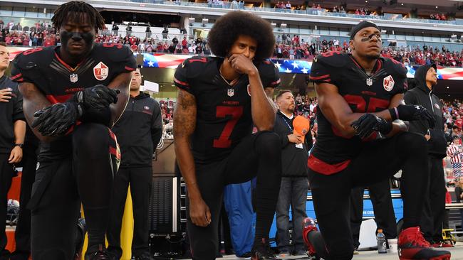 San Francisco 49ers players Eli Harold, Colin Kaepernick, and Eric Reid kneel in protest during the national anthem prior to an NFL game. Picture: AFP