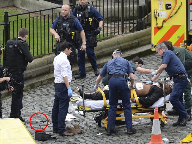 A man is treated by emergency services as police look on at the scene outside the Houses of Parliament London, Wednesday, March 22, 2017. Picture: Stefan Rousseau/PA via AP