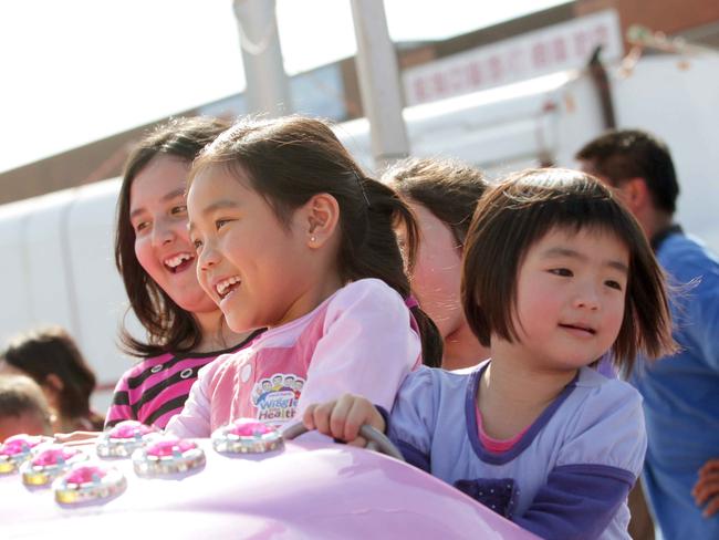 Riding the Superfast Space Rockets ride Aivy White, Ivy 6 and Danvi Nguyen 3 at the Cabramatta Moon Festival.